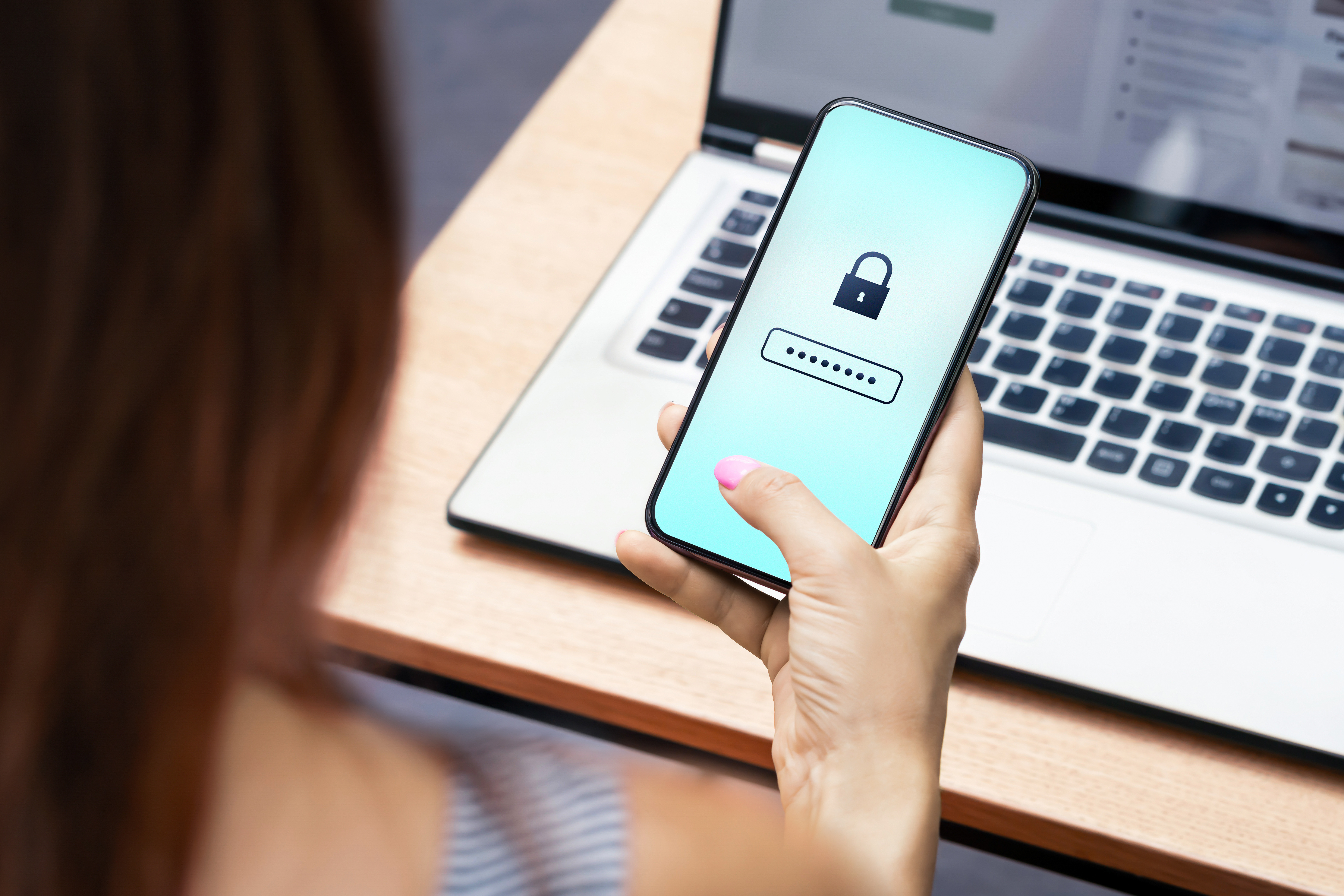 A woman looking at her smartphone and using a password manager.